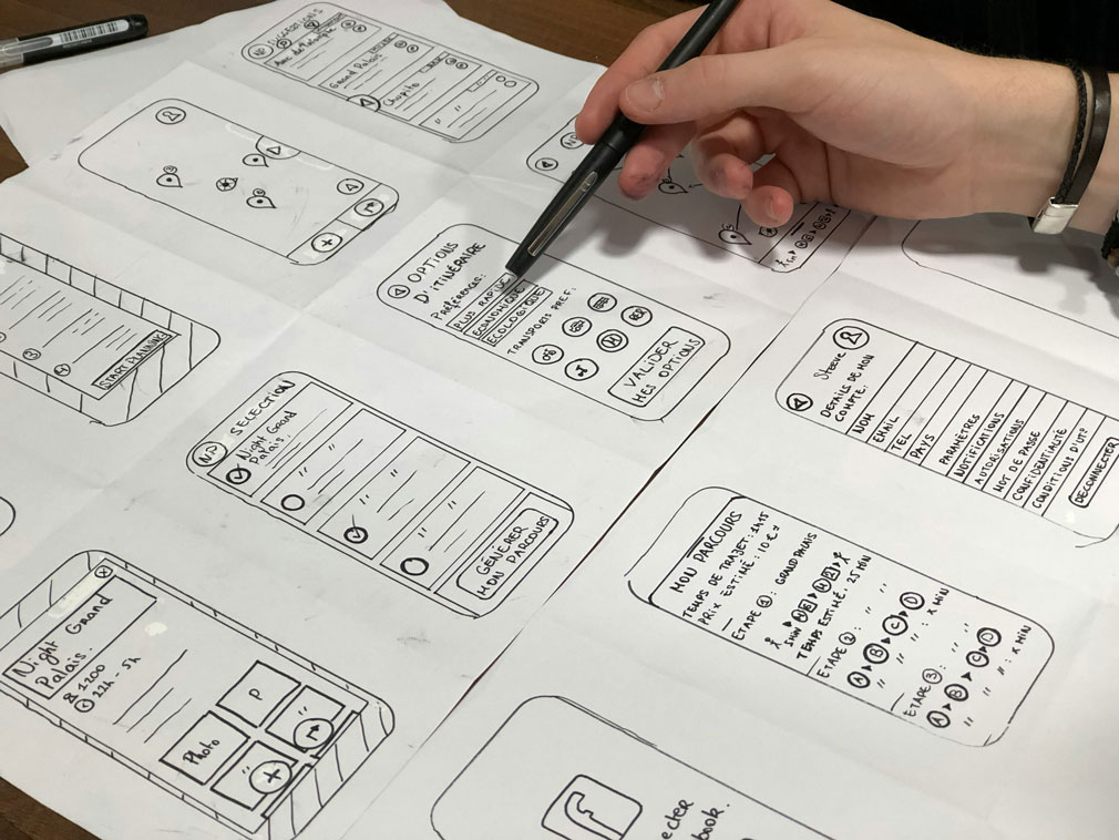 Designer looking over some UX sketches - by Amélie Mourichon Unsplash